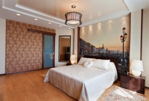 Многоуровневый лаковый натяжной потолок с освещением и люстрой в спальне