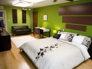 Интерьер просторной спальни в зеленом оформлении