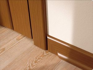 Коричневый напольный плинтус для обустройства пола в спальне