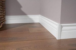 Высокий белый плинтус для обустройства пола в спальне
